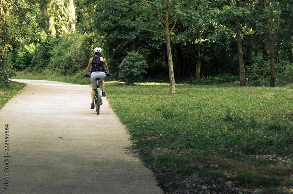 Obraz premium Arre, España, 09-14-2018: Woman riding a bike on a forest path