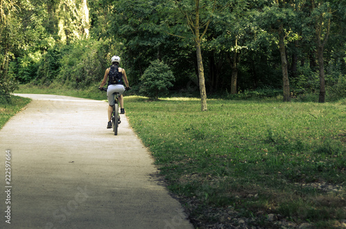 Wallpaper Mural Arre, España, 09-14-2018: Woman riding a bike on a forest path Torontodigital.ca