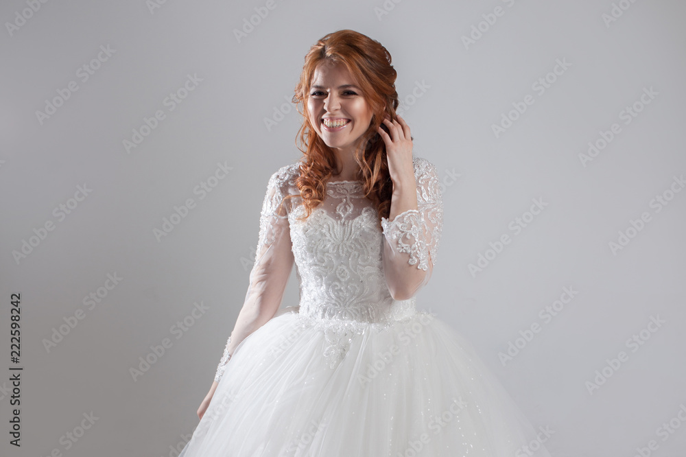 Happy laughing young woman in wedding dress. Charming bride on Light background. Happy laughing young woman in wedding dress. Charming bride on Light background.