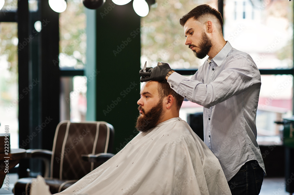 Handsome bearded man at the barbershop, barber at work. Handsome bearded man at the barbershop, barber at work.