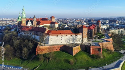 Krakow, Poland. Wawel royal Castle and Cathedral, Vistula River, park, promenade and walking people. Aerial 4K video in summer.
