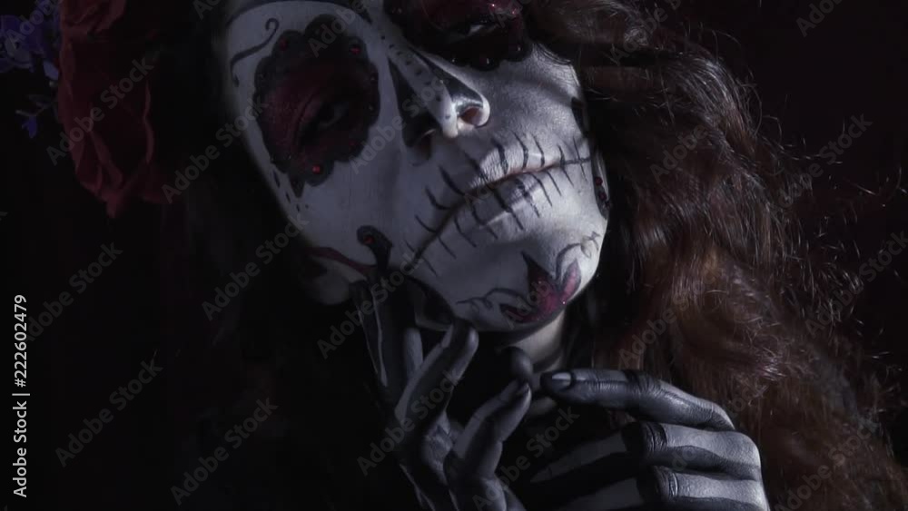 Beautiful girl in makeup Santa Muerta on halloween posing in the dark Beautiful girl in makeup Santa Muerta on halloween posing in the dark