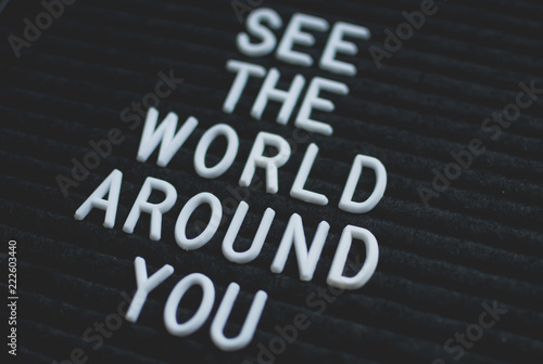 Phrase see the world around you written on the letter board. White letters on the black background. Business concept