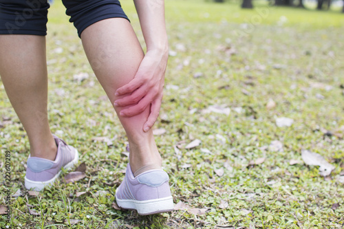 woman has got leg pain and injury after work out and exercise in park