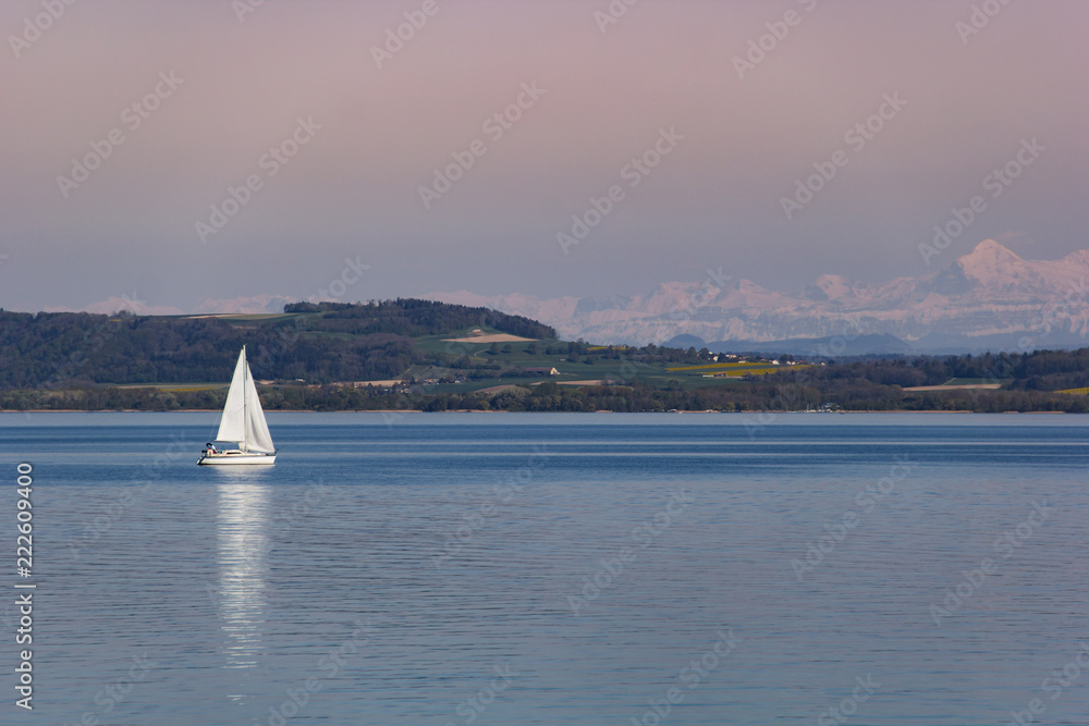 White boat sailing on Neuchâtel Lake in Switzerland