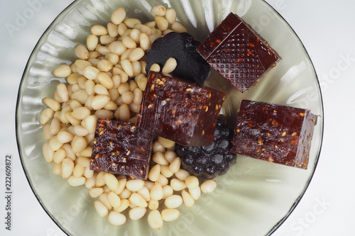 pieces of natural marmalade and pine nuts in a glass plate