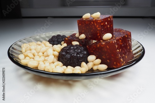 pieces of natural marmalade and pine nuts in a glass plate