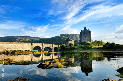 Tourists favourite place in Scotland - Isle of Skye. Very famous castle in Scotland called Eilean Donan castle.  Top of the mountains.Scottish Highlands. Castle with reflection in the lake. photo