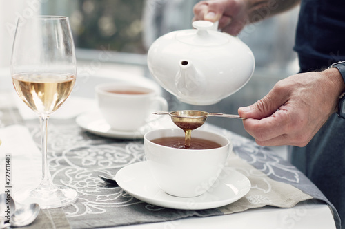 Photos Close-up shot of man’s hands preparing tea-set with beautiful luxury elegant porcelain dishes