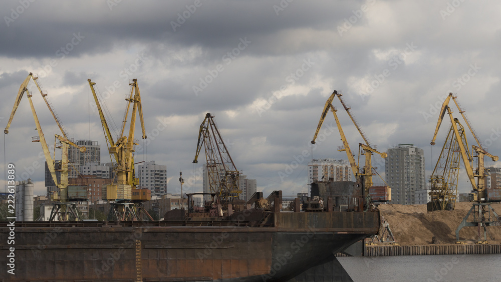 A barge on the river and cranes on the background. Format 16:9