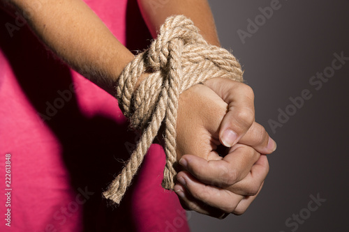 Mujer con las manos atadas con una cuerda.