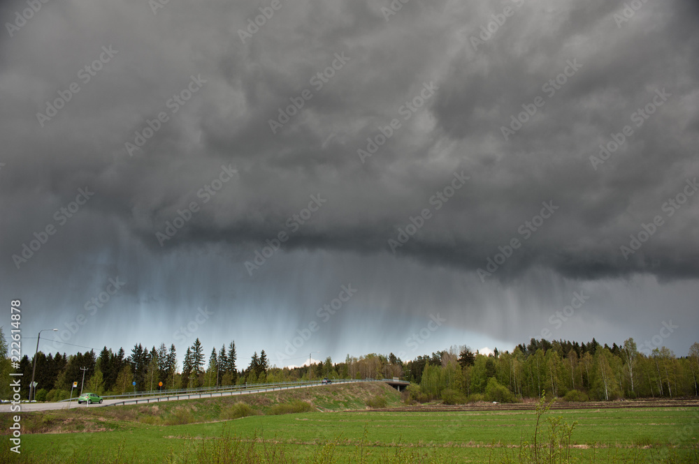 Stormy rain clouds over rural landscape in Finland.