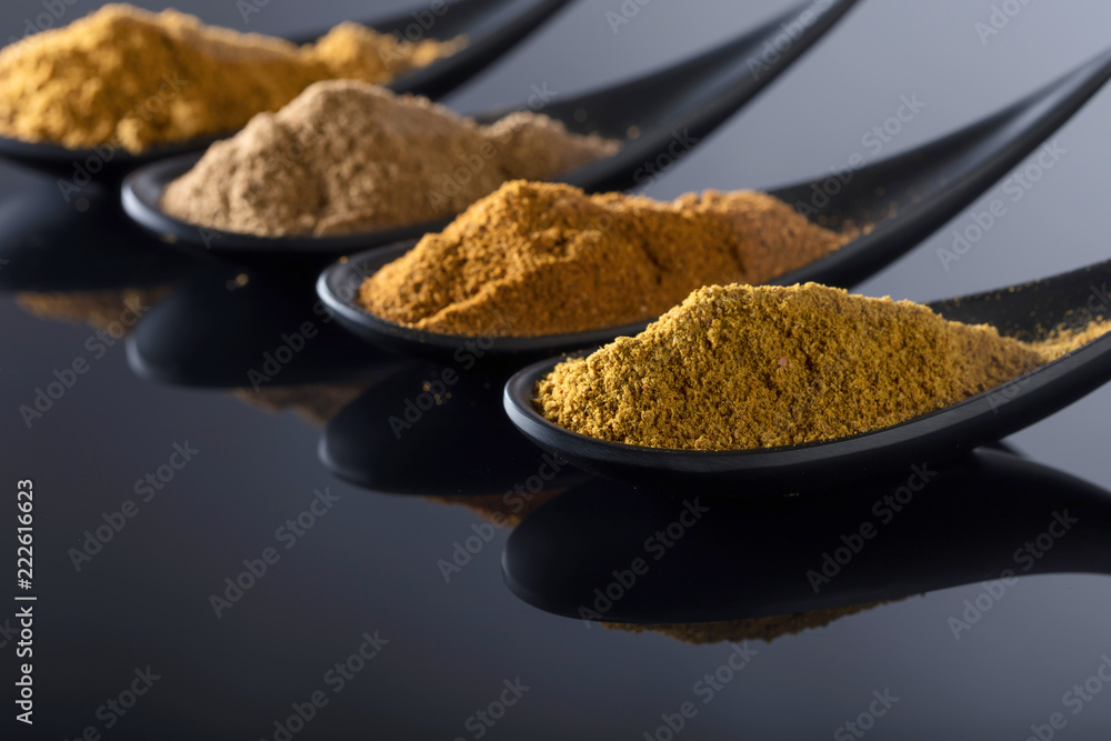 Small black bowls of Indian spices on black background . Small black bowls of Indian spices on black background .