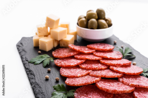 delicious sliced salami on a stone plate white background