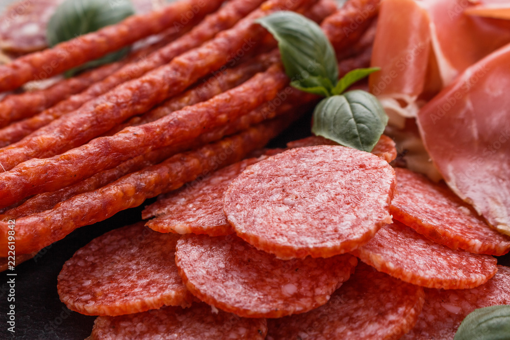 Cold smoked meat plate on a rustic wooden background Cold smoked meat plate on a rustic wooden background