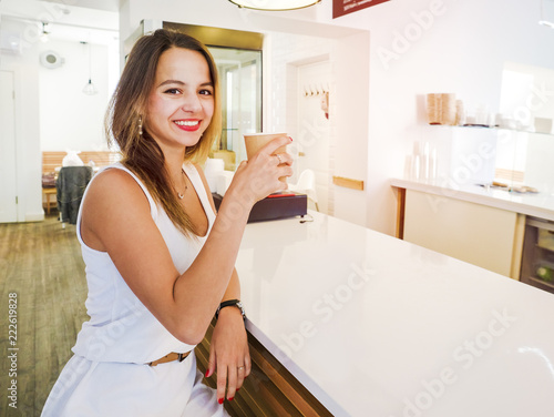 Beautiful girl drinking coffee or tea in a cafe.