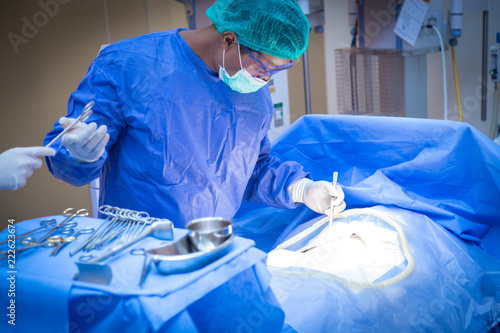 Team of surgeon in uniform perform operation on a patient at cardiac surgery clinic.