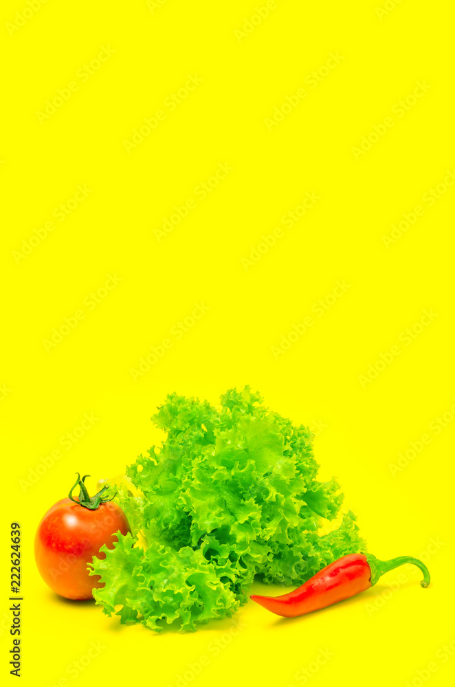 Tomato red pepper and lettuce on yellow background. Tomato red pepper and lettuce on yellow background.