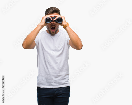 Young handsome man looking through binoculars over isolated background scared in shock with a surprise face, afraid and excited with fear expression