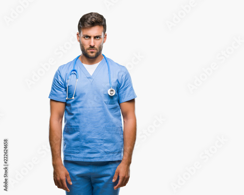 Young handsome doctor nurse man over isolated background skeptic and nervous, frowning upset because of problem. Negative person. © Krakenimages.com