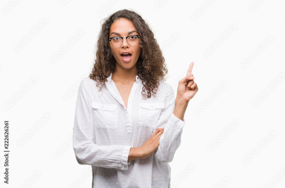 Beautiful young hispanic woman with a big smile on face, pointing with hand and finger to the side looking at the camera. Beautiful young hispanic woman with a big smile on face, pointing with hand and finger to the side looking at the camera.
