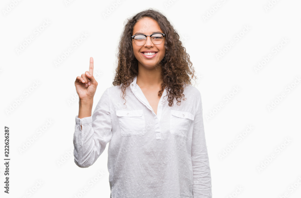 Beautiful young hispanic woman showing and pointing up with finger number one while smiling confident and happy. Beautiful young hispanic woman showing and pointing up with finger number one while smiling confident and happy.