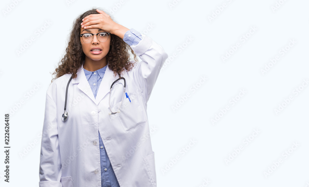 Young hispanic doctor woman stressed with hand on head, shocked with shame and surprise face, angry and frustrated. Fear and upset for mistake. Young hispanic doctor woman stressed with hand on head, shocked with shame and surprise face, angry and frustrated. Fear and upset for mistake.