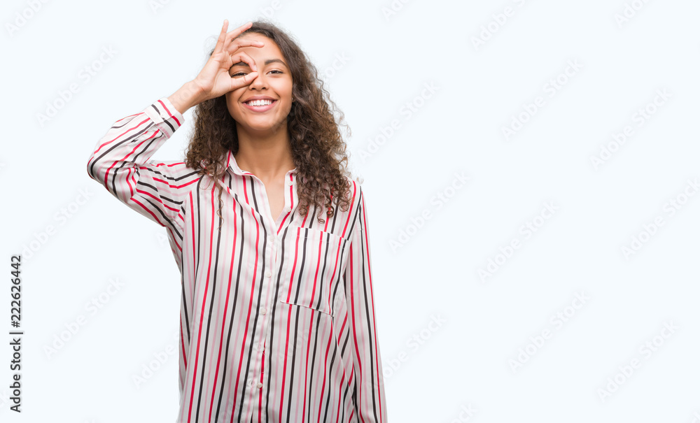 Beautiful young hispanic woman doing ok gesture with hand smiling, eye looking through fingers with happy face. Beautiful young hispanic woman doing ok gesture with hand smiling, eye looking through fingers with happy face.