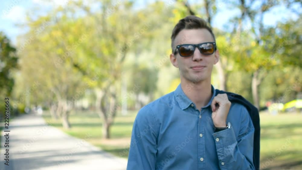 Portrait of young successful happy business man in a shirt and sunglasses laughing and smiling to the camera Portrait of young successful happy business man in a shirt and sunglasses laughing and smiling to the camera