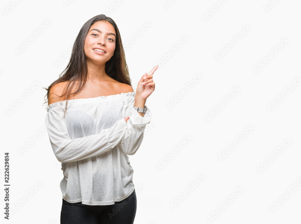 Young beautiful arab woman over isolated background with a big smile on face, pointing with hand and finger to the side looking at the camera. Young beautiful arab woman over isolated background with a big smile on face, pointing with hand and finger to the side looking at the camera.