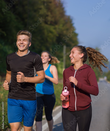 young people jogging on country road