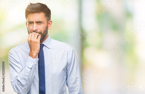 Adult hispanic business man over isolated background looking stressed and nervous with hands on mouth biting nails. Anxiety problem.