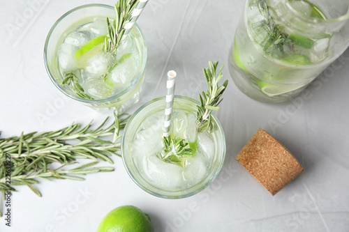 Flat lay composition with lime and rosemary cocktail on gray table