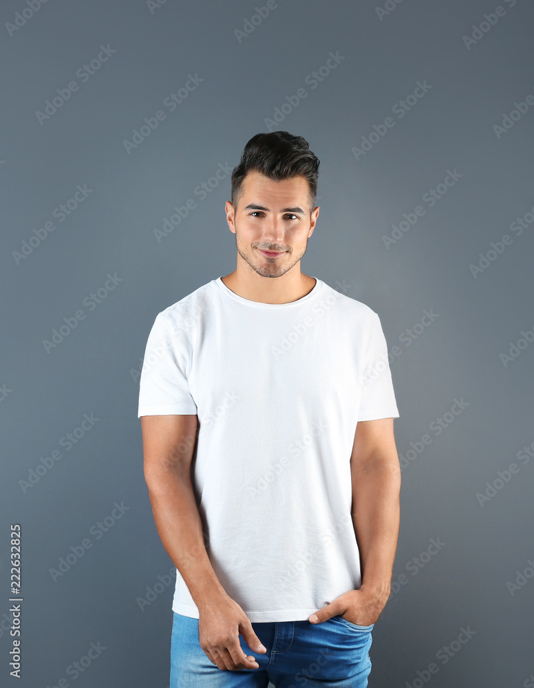 Young man in t-shirt on grey background. Mockup for design Young man in t-shirt on grey background. Mockup for design