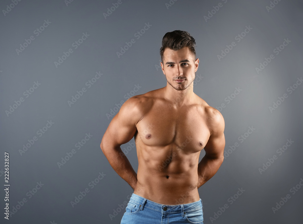 Shirtless young man in stylish jeans on grey background Shirtless young man in stylish jeans on grey background