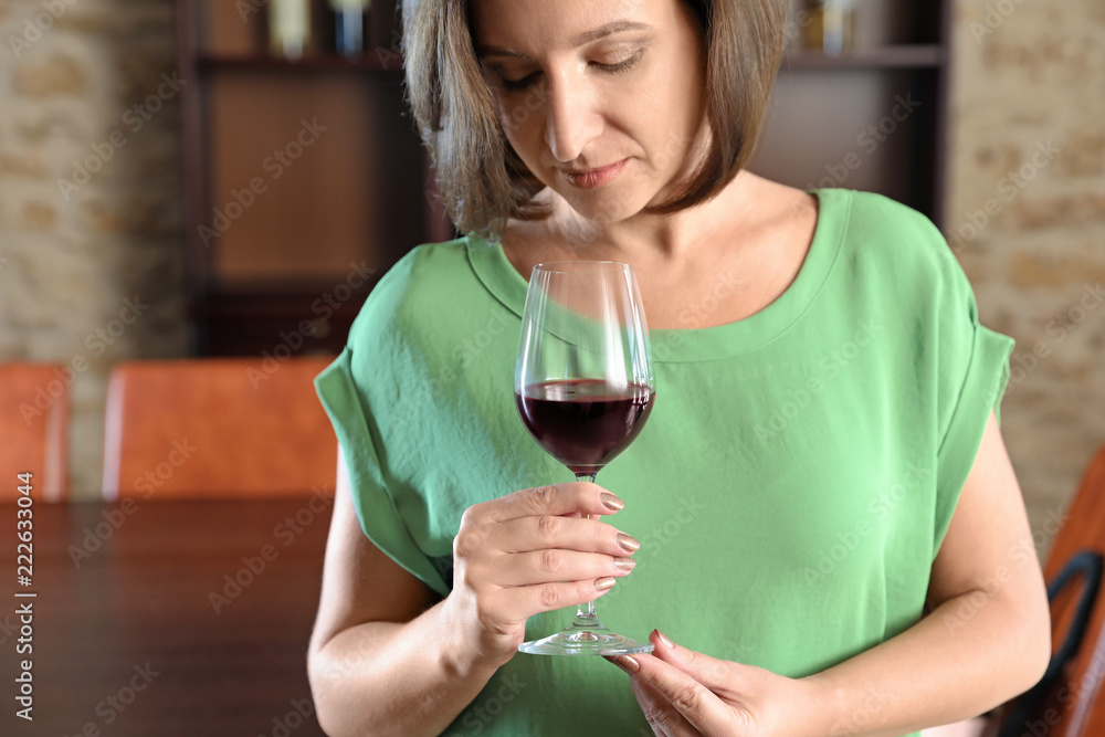 Woman with glass of red wine indoors Woman with glass of red wine indoors
