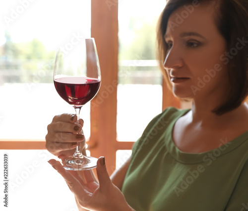 Woman with glass of red wine indoors