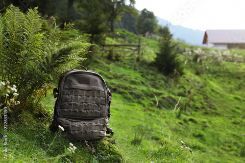 Backpack in green mountain valley. Summer camping