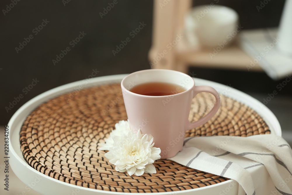 Cup of tea and flower on table indoors Cup of tea and flower on table indoors