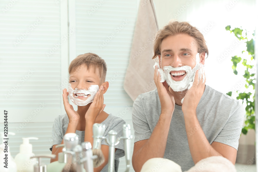 Father and son applying shaving foam in bathroom
