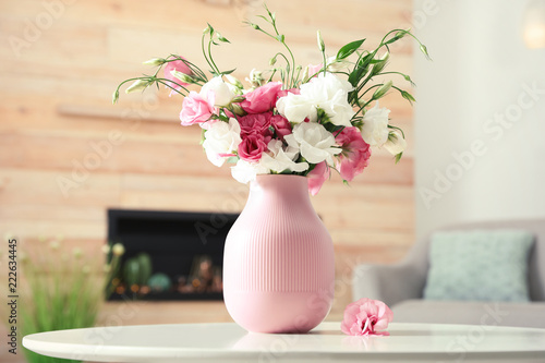 Vase with beautiful flowers on table in living room