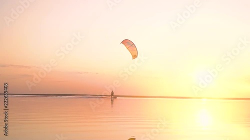 A calming dawn on the lake at sunset time, alone kiter manages a training kite photo