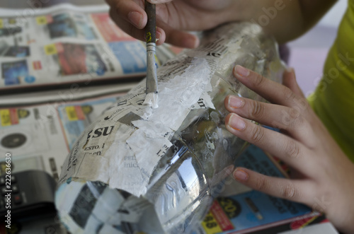 girl painting with acrylic paint a paper mask