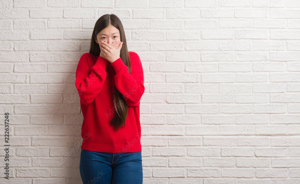 Young Chinese woman over brick wall shocked covering mouth with hands for mistake. Secret concept. Young Chinese woman over brick wall shocked covering mouth with hands for mistake. Secret concept.