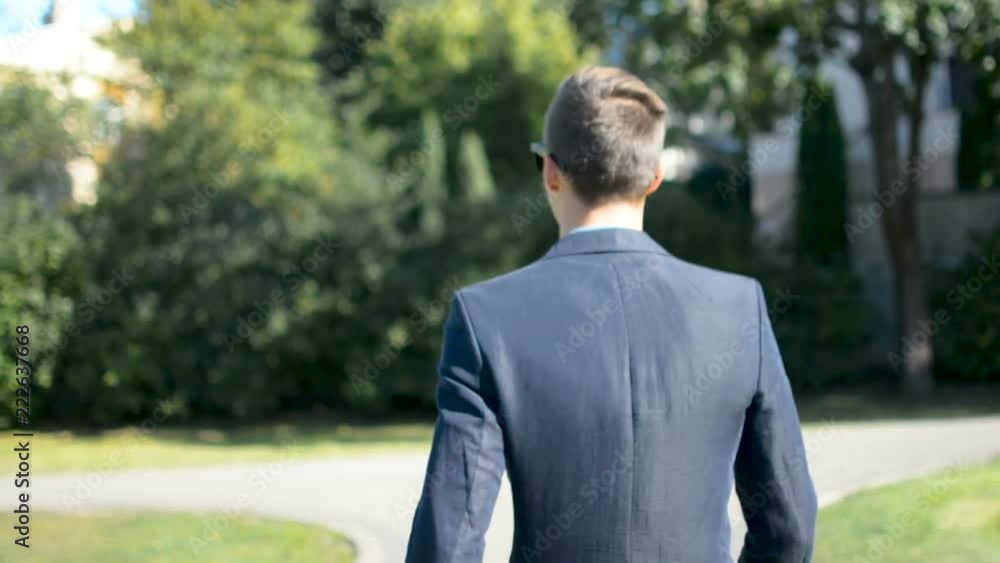 Young businessman walking forward in a hurry to job interview or meeting, back to camera Young businessman walking forward in a hurry to job interview or meeting, back to camera