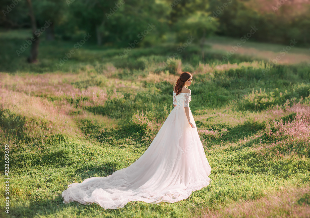 beautifull tall girl wearing white dress with long trailer gracefully in meadow of beautiful pink flowers in green grass. kind fairy, youтg woman, art photo, wedding, bride. open shoulders. light. beautifull tall girl wearing white dress with long trailer gracefully in meadow of beautiful pink flowers in green grass. kind fairy, youтg woman, art photo, wedding, bride. open shoulders. light.