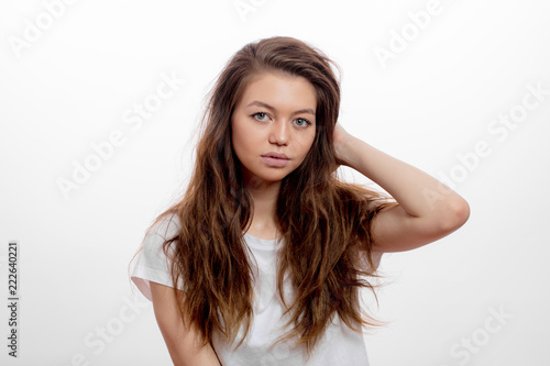 serious thoughtful awesome girl has unhealthy hair. female touching her durty hair in the morning. close up portrait. isolated white background. studio shot. photo