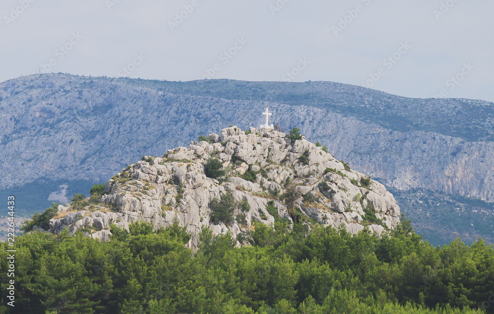 Naklejka premium Holy cross on the rocky mountain hill.