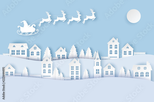 Winter urban countryside landscape village with cute paper houses, pine trees and Santa with deers flying in the sky. Merry Christmas and New Year paper art background