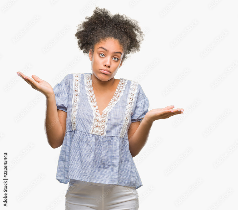 Young afro american woman over isolated background clueless and confused expression with arms and hands raised. Doubt concept. Young afro american woman over isolated background clueless and confused expression with arms and hands raised. Doubt concept.